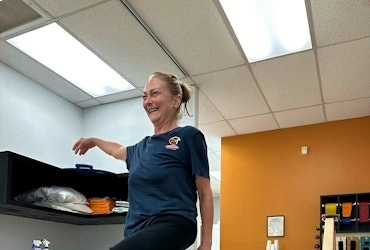 Physical therapist demonstrating a therapeutic movement exercise inside the clinic