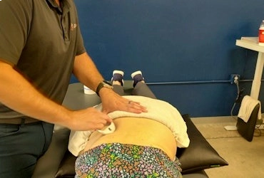 Physical therapist performing manual therapy on a patient's lower back