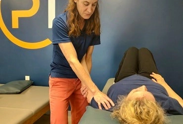 Physical therapist providing hands-on treatment to a patient lying on a therapy table