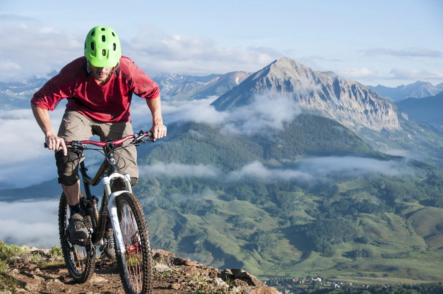 A mountain biker on a ridge above the valley near Crested Butte