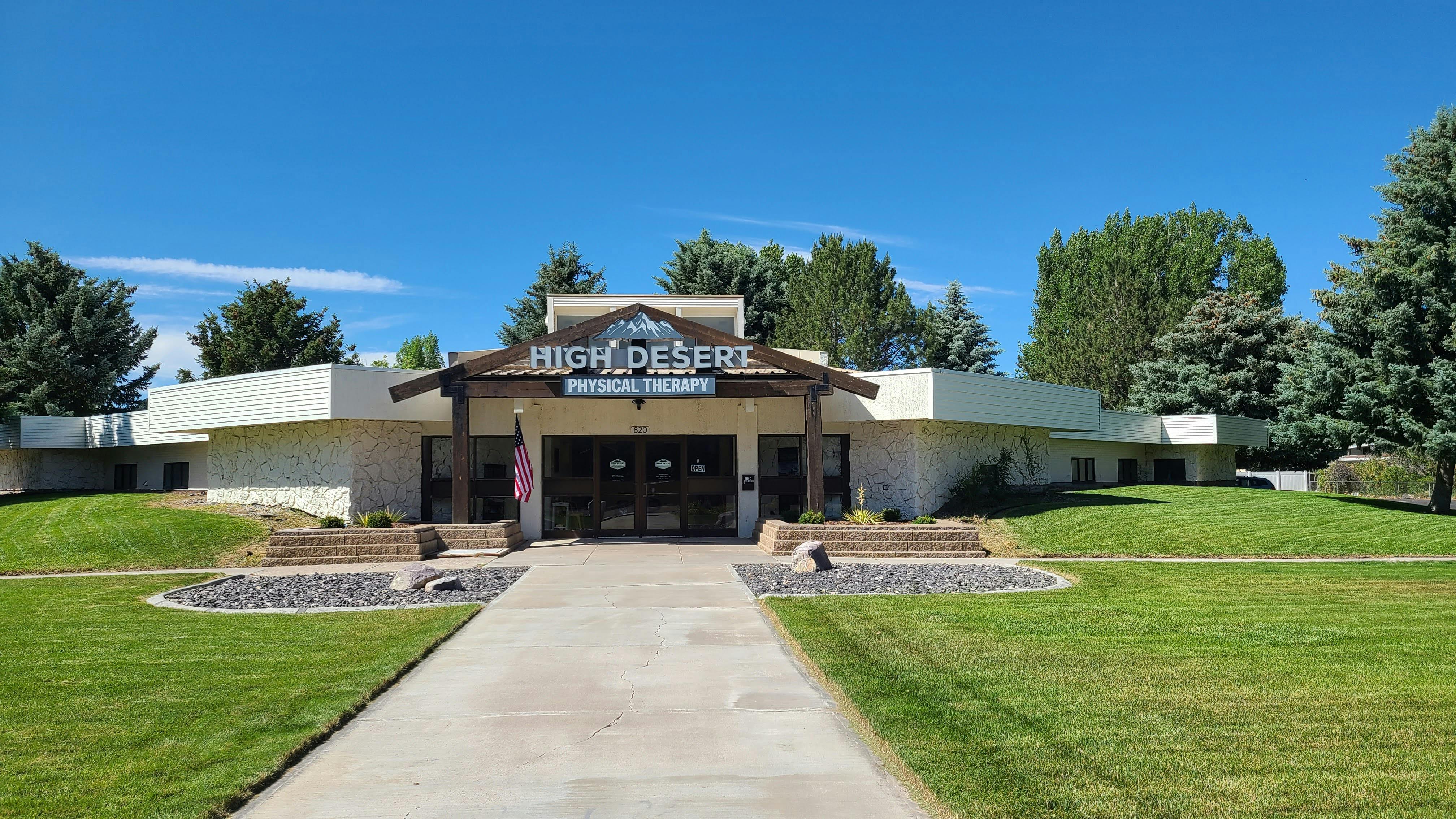 The High Desert Physical Therapy building in Chubbuck, Idaho, with a timber entrance and an American flag
