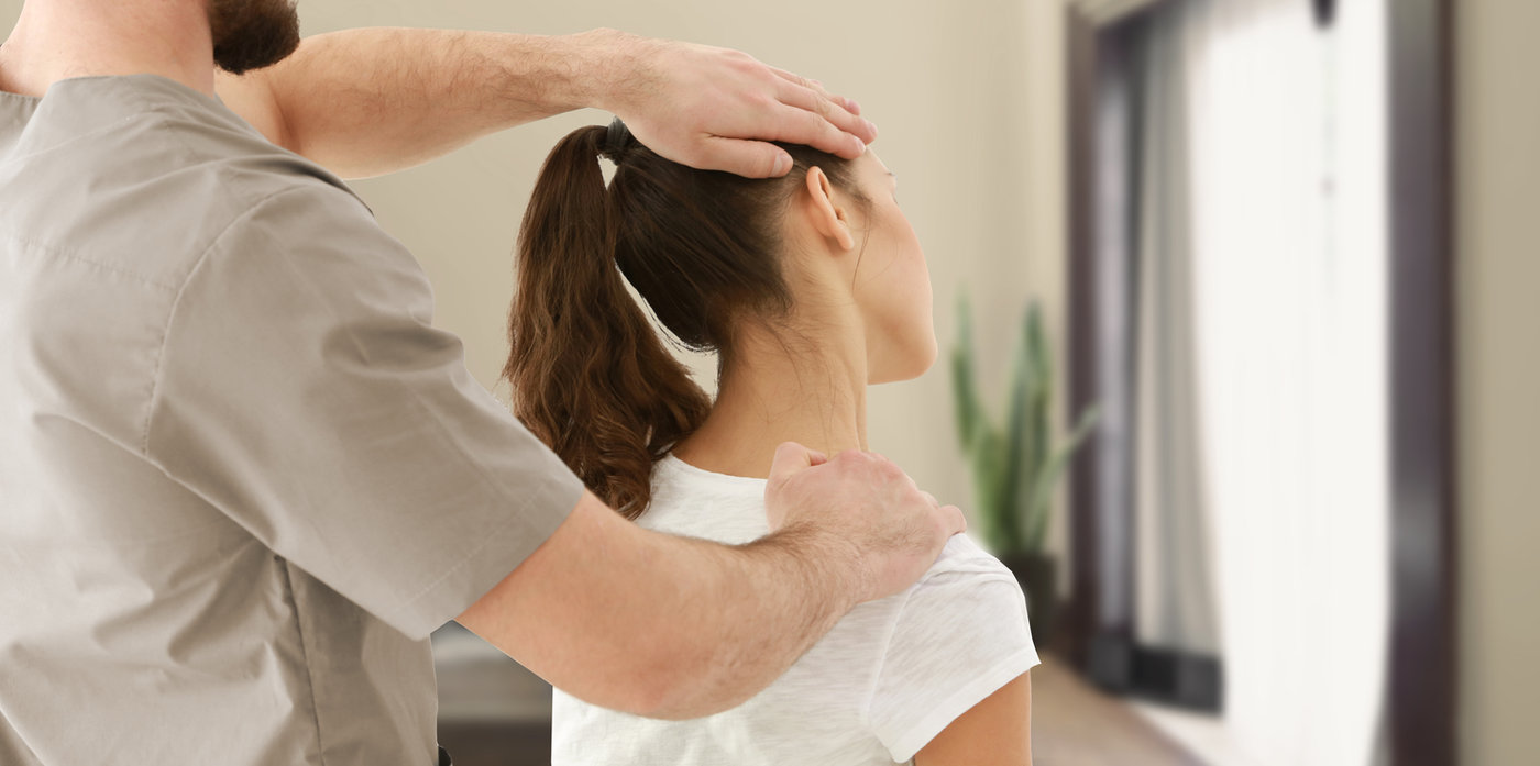 A physical therapist guiding a patient’s head into position