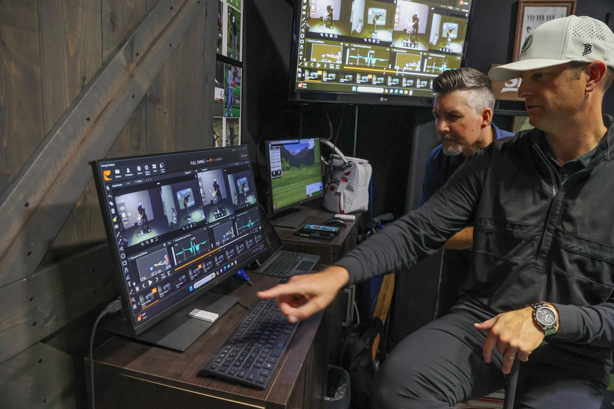 Two men studying motion capture footage on computer monitors in the Sports Lab