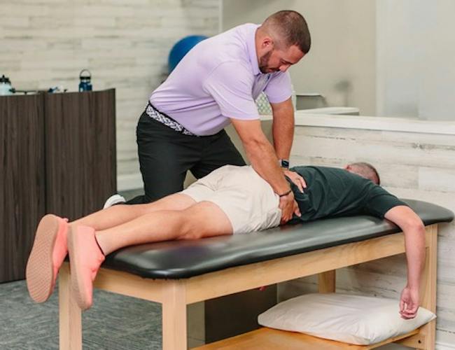 A physical therapist using joint mobilization on a patient’s shoulder