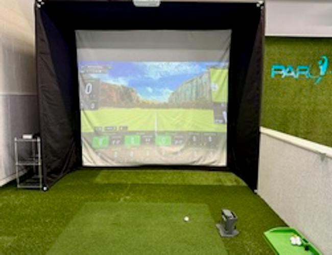 A golfer swinging in front of the golf simulator at PAR Physical Therapy