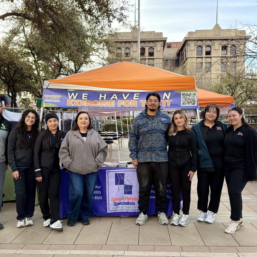Team members gathered at an outdoor event tent