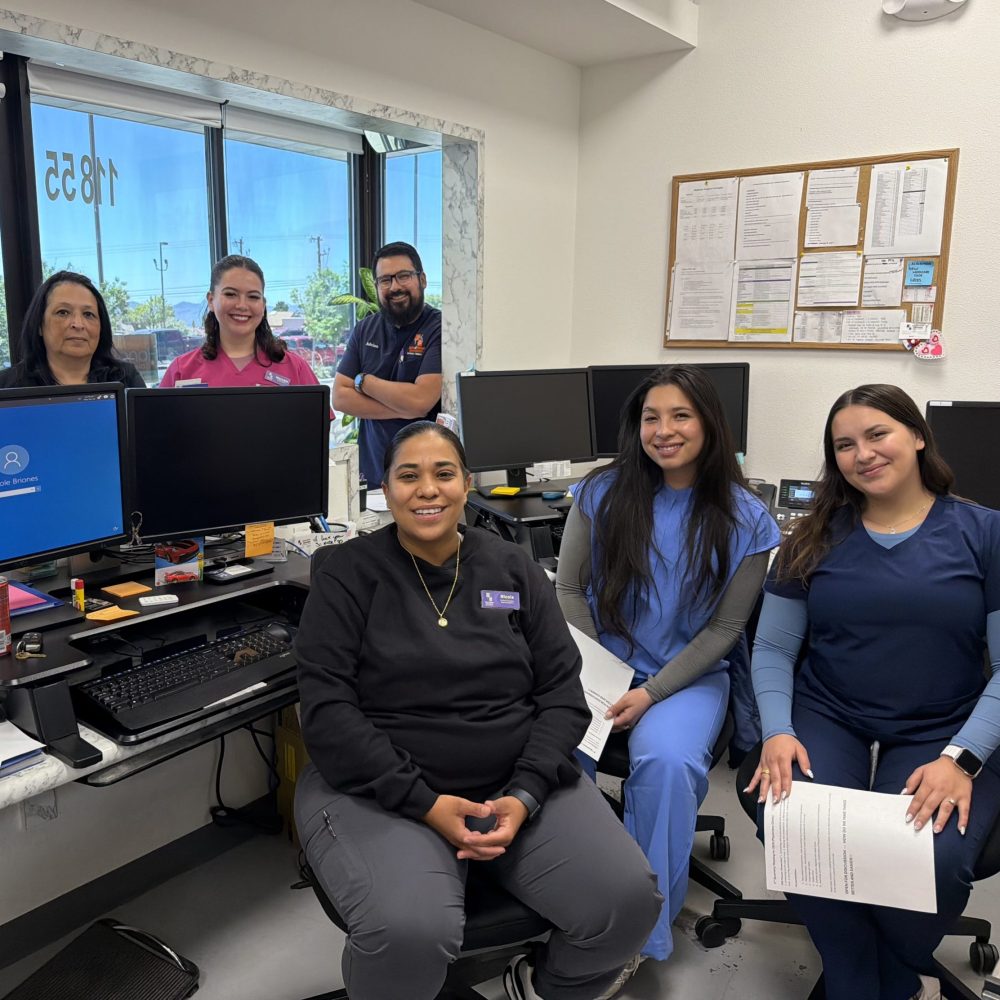 Team members and patients working at computers in the clinic office