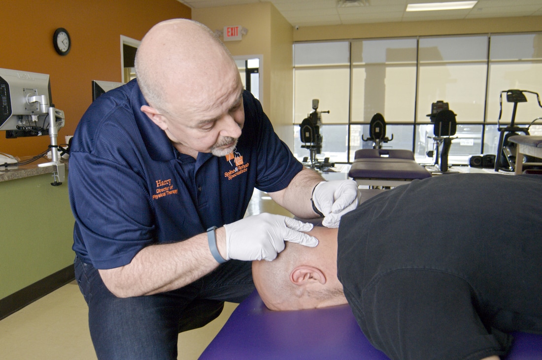 A physical therapist using hands-on treatment on a patient’s neck