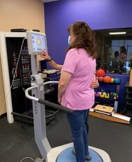 A patient standing on a balance platform during physical therapy