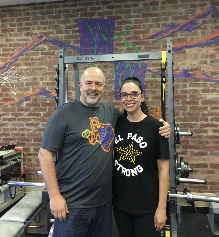 A patient and a therapist standing together in the clinic gym