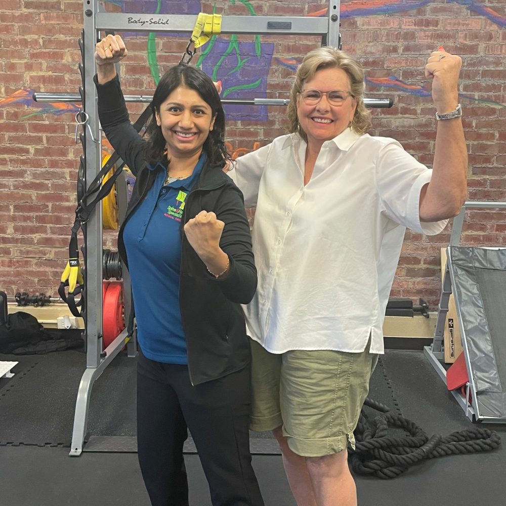 Two women posing in the gym area