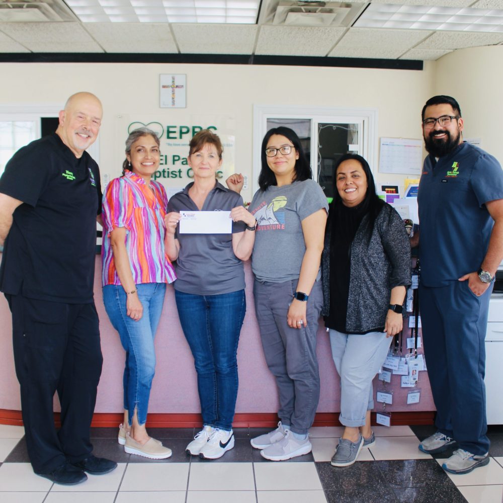 Six team members posing together at the clinic front desk